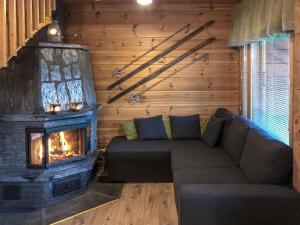 a living room with a couch and a fireplace at Holiday Home Utsunusko a by Interhome in Levi