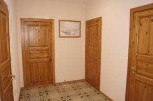 Habitación con 2 puertas de madera y suelo de baldosa. en Mini-Hotel Ilma, en Petrozavodsk