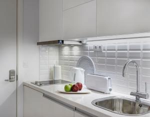 a kitchen counter with a sink and fruit on a plate at Porto Apartments - Bombarda 451 Suites in Porto +110 photos