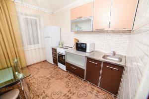 a small kitchen with a sink and a refrigerator at Modus Apartment in Tobolsk