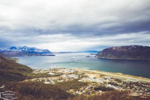 an aerial view of a large body of water with mountains at Reisafjord Hotel in Sørkjosen