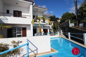 a swimming pool in front of a house at GuestHouse Vila Lusitania in Funchal