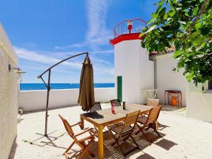 a table and chairs with a lighthouse and the ocean at Holiday Home Verudica by Interhome in Pješčana Uvala 