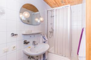 Baño blanco con lavabo y espejo en Stabentheiner-Hof, en Liesing