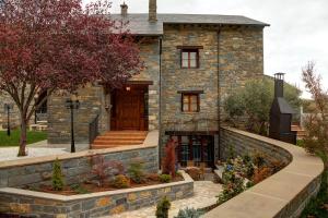 a stone house with a stone wall at Casa Rural Villa Gervasio in Fiscal