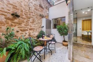 a patio with a table and chairs and plants at Ca Se Predine - Mediterranean Styled Townhouse in Alcudia