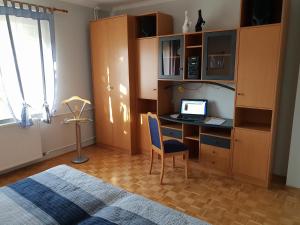 - une chambre avec un bureau, un ordinateur portable et un lit dans l'établissement Apartment Milena, à Maribor