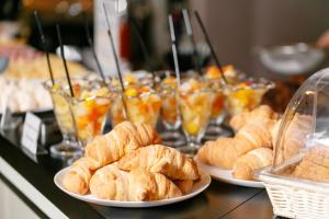 a buffet with plates of croissants and other pastries at Villa Areto in Kamares