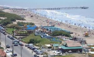 a beach with a lot of people and a pier at Maraja1 in Mar de Ajó +2 photos