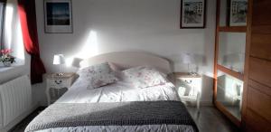 a bedroom with a bed with two nightstands and two lamps at La fermette in Tréméoc