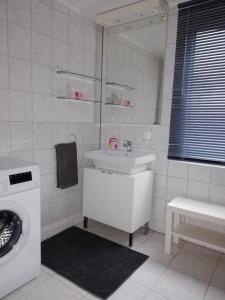 a bathroom with a sink and a washing machine at Ferienwohnung am Töpferplatz in Höhr-Grenzhausen