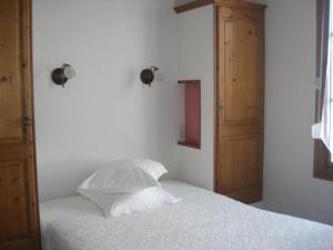 a bedroom with a white bed and a wooden door at La Marjolaine in Juan-les-Pins