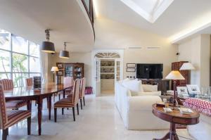 a living room with a table and a white couch at Maspalomas Golf Luxury Villa - Royal Palm in San Bartolomé de Tirajana