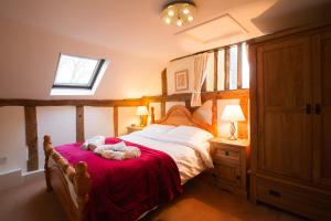 a bedroom with a bed with a teddy bear on it at Oak Cottage in Thorndon