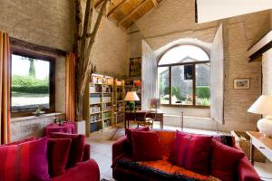 a living room with red furniture and a large window at La Vayssade - Grand Gîte de charme - 14 pers - Piscine & Jacuzzi in Lalbenque