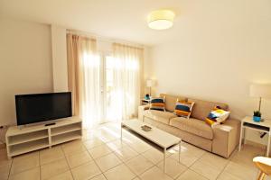 a living room with a couch and a tv at Las Casitas de la Playa in Vera