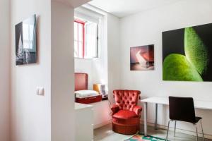 uma sala de estar com uma cadeira vermelha e uma mesa em Art Gallery Apartment em Lisboa