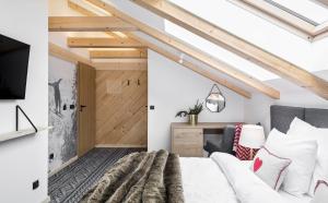 sypialnia z łóżkiem, telewizorem i kanapą w obiekcie Villa Górska Ski & Bike w Wiśle