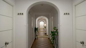 an archway leading to a hallway with plants at Leo San Bruno in Isla Canela