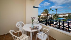 a balcony with a table and chairs and a view of the ocean at Leo San Bruno in Isla Canela