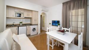 a kitchen and living room with a white table at Leo San Bruno in Isla Canela