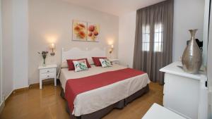 a bedroom with a large bed with red pillows at Leo San Bruno in Isla Canela