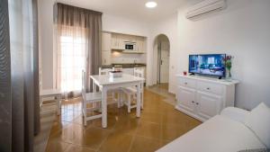 a kitchen and living room with a table and a tv at Leo San Bruno in Isla Canela