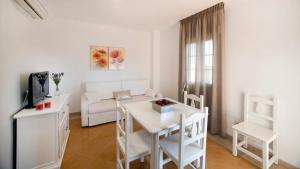 a white living room with a white table and chairs at Leo San Bruno in Isla Canela