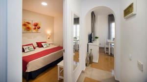 a bedroom with a bed and a room with a table at Leo San Bruno in Isla Canela