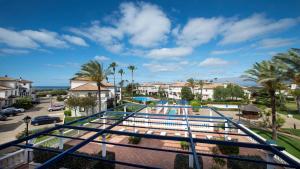 a view of the pool at a resort with palm trees at Leo San Bruno in Isla Canela