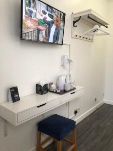 a kitchen with a television and a sink at Berjaya Eden Park London Hotel in London