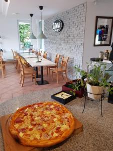 a large pizza sitting on a table in a restaurant at Dziwnów Wczasowisko in Dziwnów