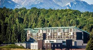 a large apartment building with mountains in the background at B09 Mauritius - Silver Mountain in Poiana Brasov