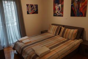 a bedroom with a bed with towels on it at Georgina's cozy apartment -Metropolitan Hospital- in Piraeus