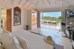 1 dormitorio con cama y vistas al océano en Mystique luxury villa at the heart of the island, en Gustavia