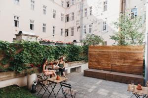 zwei Personen sitzen an einem Tisch auf einer Terrasse in der Unterkunft Miss Sophie's New Town & Wellness in Prag