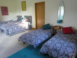 a bedroom with two beds and a window at Hill View in Binegar