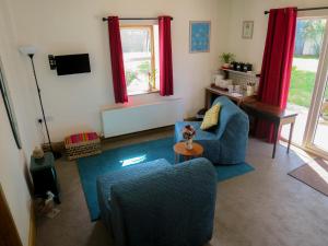 uma sala de estar com um sofá azul e uma mesa em Hill View em Binegar