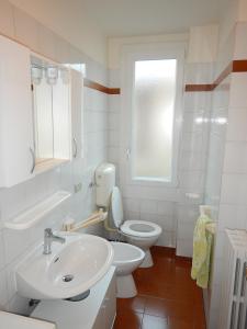 a white bathroom with a toilet and a sink at Appartamento Angelina in Stresa