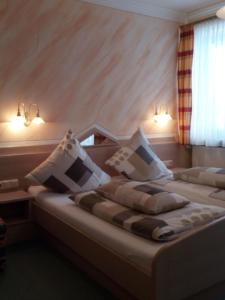 a bedroom with two beds with white pillows at Gasthof-Hotel Dilger in Rattenberg