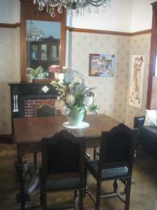 una mesa de comedor con un jarrón de flores. en Villa Belle Epoque, en Hamoir