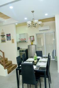 a dining room with a black table and chairs at MAILZ HAVEN BEAUTIFL 3BR MODERN APRT NEAR SM DOOR-C in Davao City