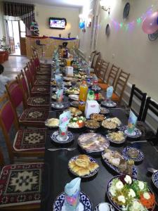 una mesa larga llena de platos de comida en Boutique Hotel Parvina, en Bukhara
