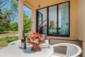 un tavolo con un cesto di fiori e una bottiglia di vino di Keser Apartments a Rovigno (Rovinj)