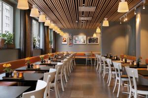 a dining room with tables and white chairs at Elite Hotel Arcadia in Stockholm