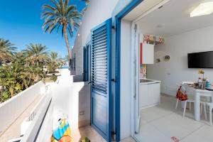 a balcony with a view of the beach and palm trees at Residence Le Palme in San Vito lo Capo