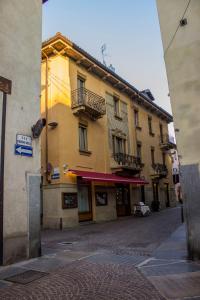 a yellow building with balconies on a street at Palazzo Belli in Alba