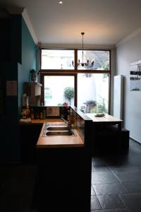 a kitchen with a sink and a large window at Hostel Lybeer Bruges in Bruges