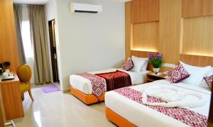 a hotel room with two beds and two lamps at Easy Hotel KL Sentral in Kuala Lumpur