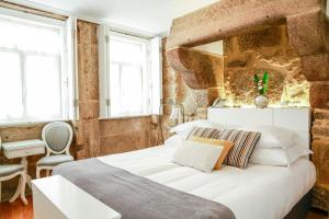 a bedroom with a white bed and white walls at 1872 River House in Porto